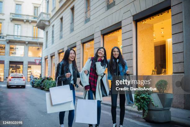 asian women shopping together, outdoors, smiling - milan fashion stock pictures, royalty-free photos & images