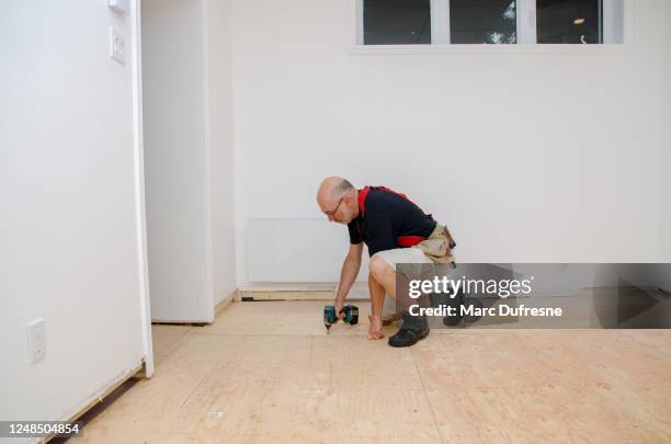 man building a floor in home basement - basement stock pictures, royalty-free photos & images