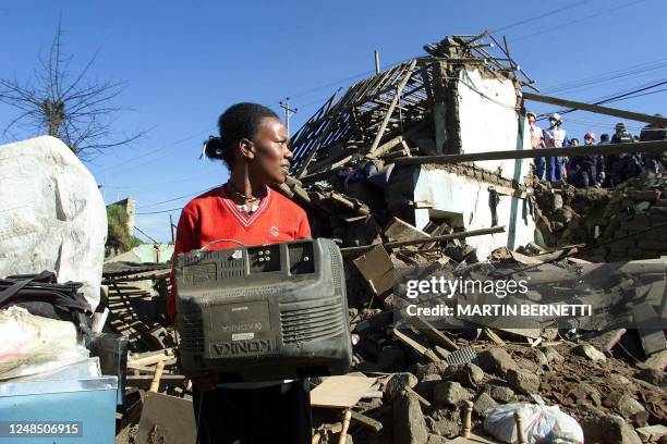 Raquel Cortez carries belongings from her damaged home caused by an exploding pipe alternating diesal, gasoline, and oil in Quito, Ecuador 17 April...