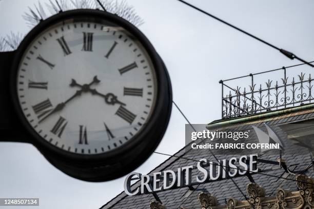 Sign of Credit Suisse is seen behind a clock at the headquarters of Switzerland's second-biggest bank in Zurich on March 18, 2023. - Switzerland's...