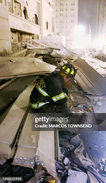 Emergency Medical Technician Joe Civinski holds his face in his hands in the debris of the World Trade Center in New York, 12 September, 2001. AFP...