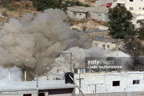 Smoke and debris rise from the home of Nabil Sharabati, a Palestinian man whose sons are on the Israeli wanted list, after the army evacuated the...