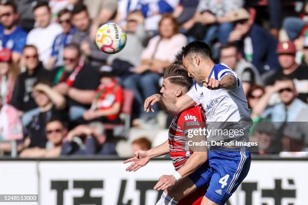 Ermedin Demirovic of FC Augsburg and Maya Yoshida of FC Schalke 04 battle for the ball during the Bundesliga match between FC Augsburg and FC Schalke...