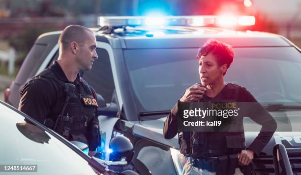 two police officers by their patrol cars, on radio - police stock pictures, royalty-free photos & images