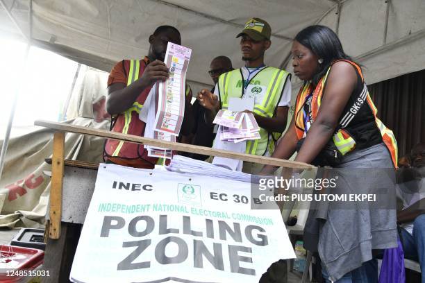 Officials of the Independent National Electoral Commission count votes at a polling station after local elections, in Lagos on March 18, 2023. -...