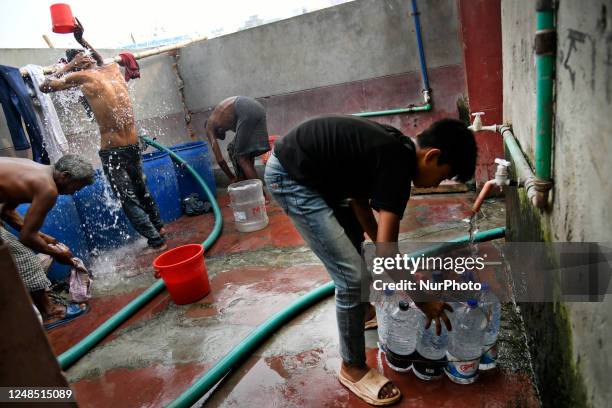 Child refills plastic bottles to sale to launch passengers at a low price beside the Buriganga river in Dhaka, Bangladesh on Saturday, March 18,...