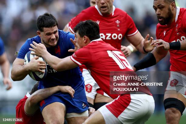 France's hooker Julien Marchand is tackled by Wales' wing Louis Rees-Zammit during the Six Nations rugby union international match between France and...