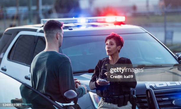 policewoman taking a statement from young man - maritime police stock pictures, royalty-free photos & images