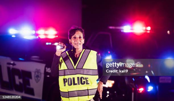 african-american policewoman searching with flashlight - police flashlight stock pictures, royalty-free photos & images