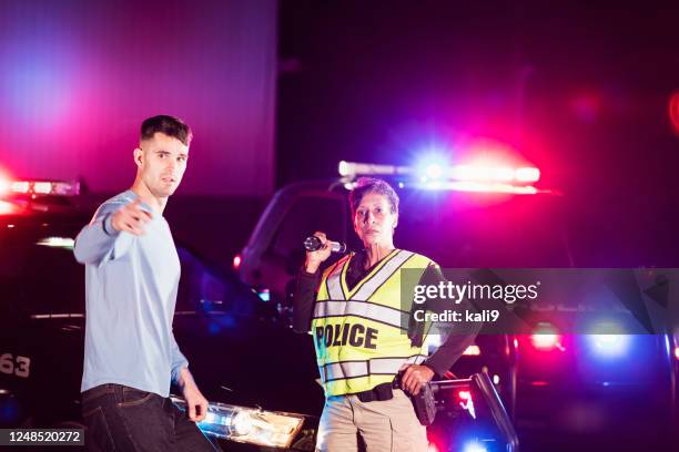 policewoman at night talking with young man - police car side view stock pictures, royalty-free photos & images