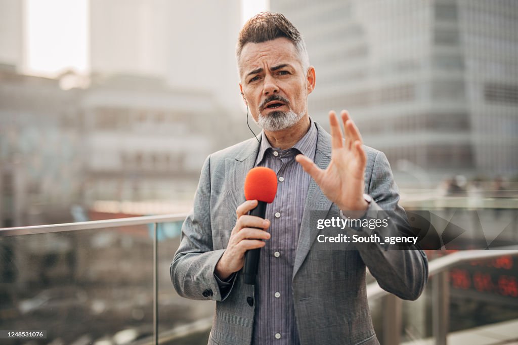 Bel reporter maschio nelle trasmissioni in diretta trasmette le notizie di oggi