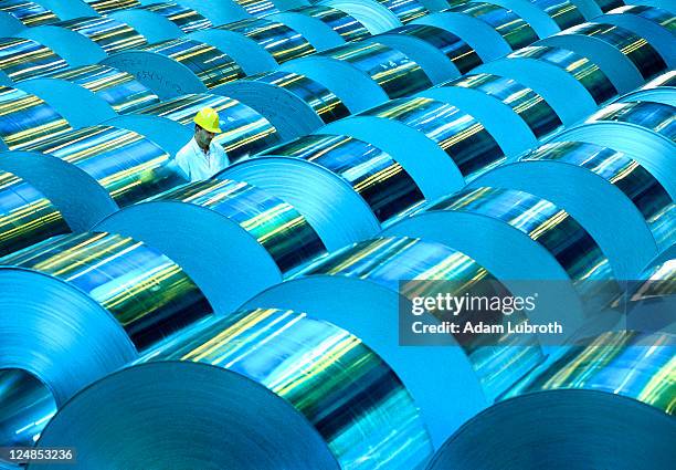 worker with stock aluminum reels - materiaal stockfoto's en -beelden