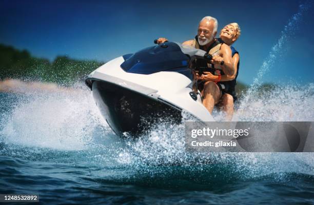 senior couple jet skiing. - jet ski stock pictures, royalty-free photos & images