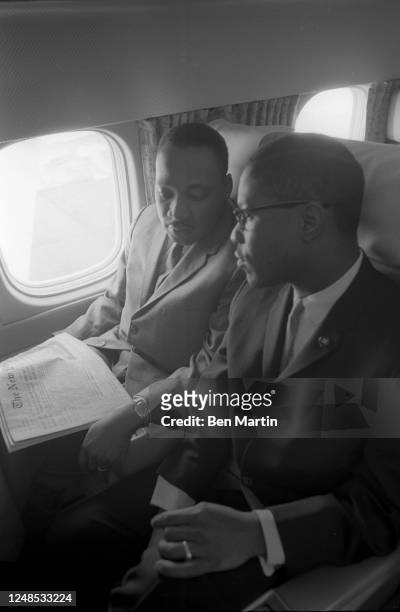 American Christian minister and activist Martin Luther King Jr conferring with American activist Bayard Rustin aboard a flight, December 24th, 1963.