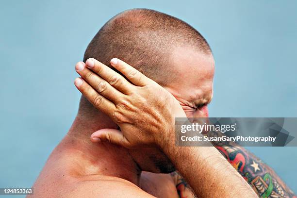 young man holding hands over ears - covering ears stock-fotos und bilder