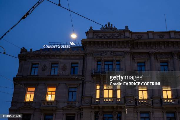 This photograph taken on the evening of March 18 shows lights from windows of the headquarters of the Credit Suisse bank in Zurich. - Switzerland's...
