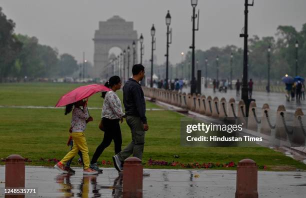Visitors out in the rainy Day on Kartavya Path near Rashtrapati Bhawan on March 18, 2023 in New Delhi, India.