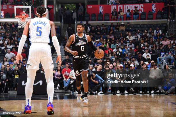 Paul George of the LA Clippers moves the ball during the game against the Orlando Magic on March 18, 2023 at Crypto.Com Arena in Los Angeles,...