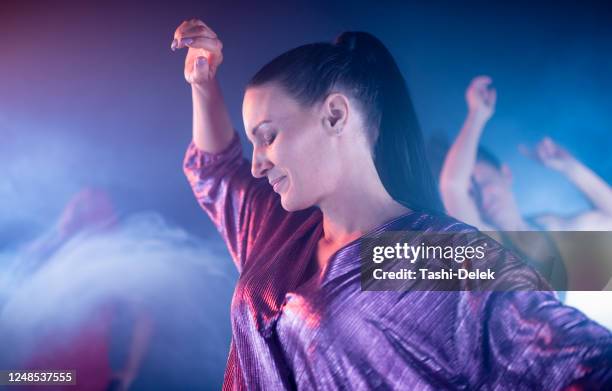 mujer bailando en el club nocturno - high ponytail fotografías e imágenes de stock