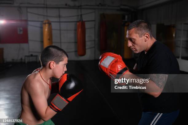 boy training kickboxing with trainer - martial arts kid stock pictures, royalty-free photos & images