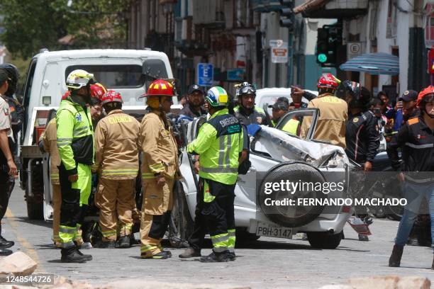 Soldiers and firefighters work at the place where the cornice and terrace of a building located in Cuenca's historic center fell and destroyed a car,...