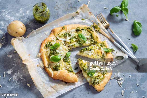 pizza with potatoes, mozzarella cheese  and basil pesto. - pestosaus stockfoto's en -beelden