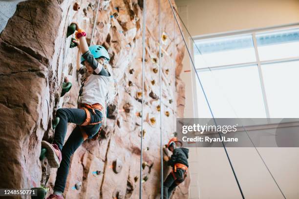 children climbing indoor rock wall - crag stock pictures, royalty-free photos & images