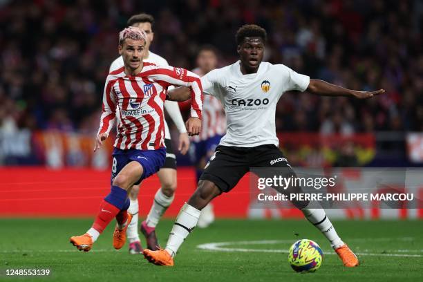 Atletico Madrid's French forward Antoine Griezmann vies with Valencia's US midfielder Yunus Musah during the Spanish league football match between...