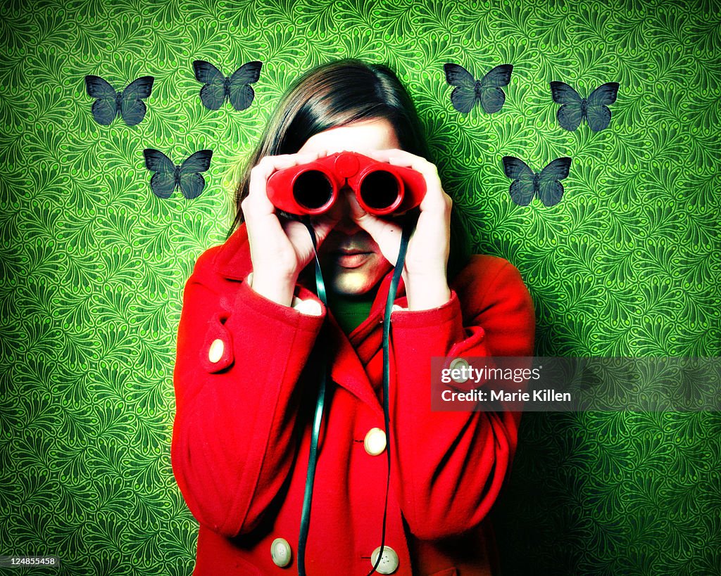 Woman in red coat and red binoculars