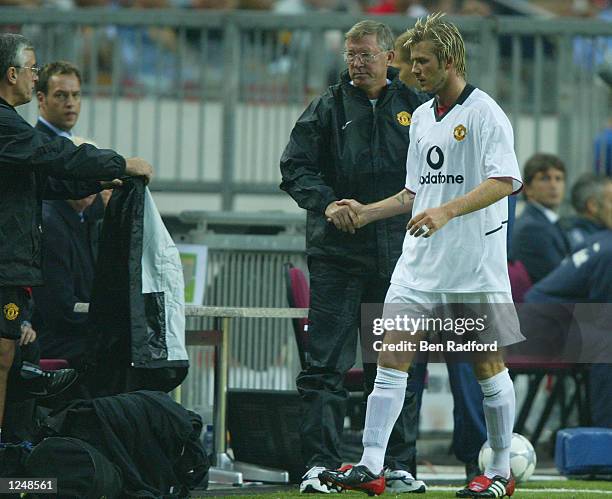 David Beckham of Manchester United leaves the field and shakes hands with his manager Sir Alex Ferguson during the third match of the Amsterdam pre...