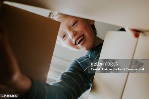 happy boy looking into a box - regalo foto e immagini stock