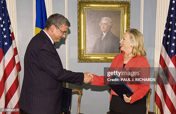 Romanian Foreign Minister Teodor Basconschi and US Secretary of State Hillary Clinton shake hands after signing a Ballistic Missile Defense Agreement...