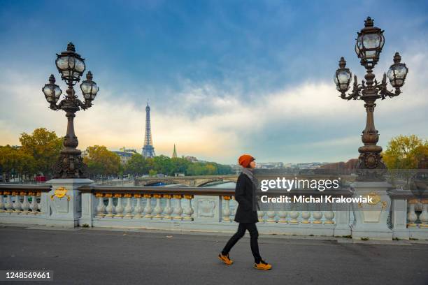 woman walking on a bridge in paris - pont alexandre iii stock pictures, royalty-free photos & images