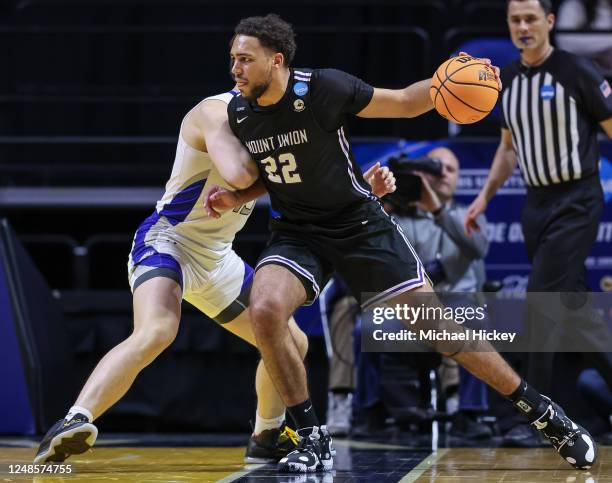 Christian Parker of Mount Union Purple Raiders drives to the basket against Caleb Furr of Christopher Newport Captains during the first half during...