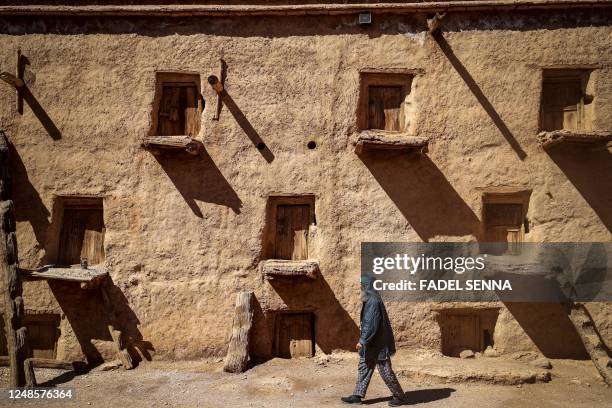 Guardian Lahcen Boutirane walks at the ancient collective granary of Ait Kine village in Morocco's region of Tata on March 1, 2023. - High in the...