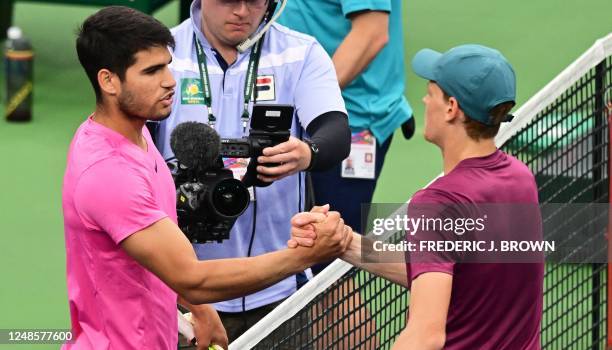 Carlos Alcaraz of Spain meets with Jannik Sinner of Italy at the net following Alcaraz's victory in their semifinal match at the 2023 ATP Indian...