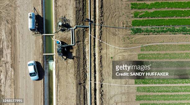 This aerial view shows irrigation pumps on a canal through agriculture fields in Holtville, California, on February 9, 2023. - A blanket of crops...