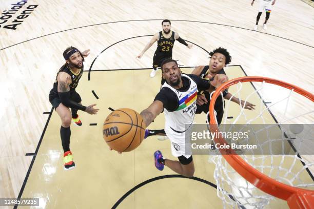 Naz Reid of the Minnesota Timberwolves drives to the net by Gary Trent Jr. #33 and Scottie Barnes of the Toronto Raptors during second half of their...