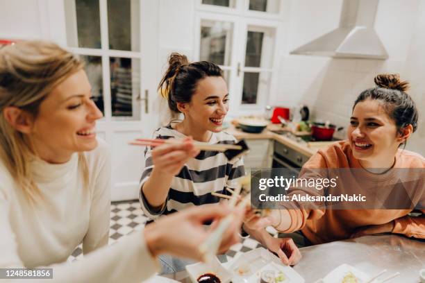 meisjes die diner samen thuis hebben - dinner party at home stockfoto's en -beelden