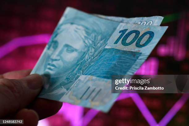 hand holding brazilian money - 100 bill stock-fotos und bilder