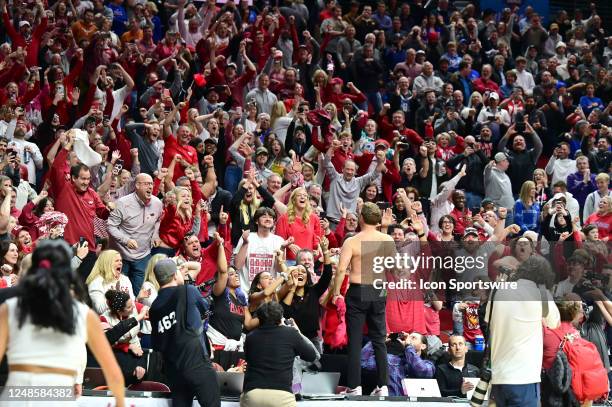 Arkansas Razorbacks coach Eric Musselman removes his shirt and celebrates with the Arkansas fans after upsetting Kansas during the second round of...