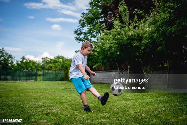 junge zeigt seine fußballer-fähigkeiten im hinterhof - backyard football stock-fotos und bilder