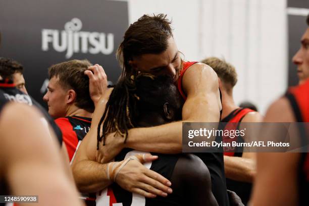 Anthony McDonald-Tipungwuti of the Bombers hugs Sam Draper of the Bombers during the 2023 AFL Round 01 match between the Hawthorn Hawks and the...