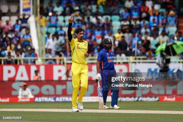 Mitchell Starc of Australia celebrates the wicket of Shubman Gill of India as Rohit Sharma of India looks on during game two in the One Day...