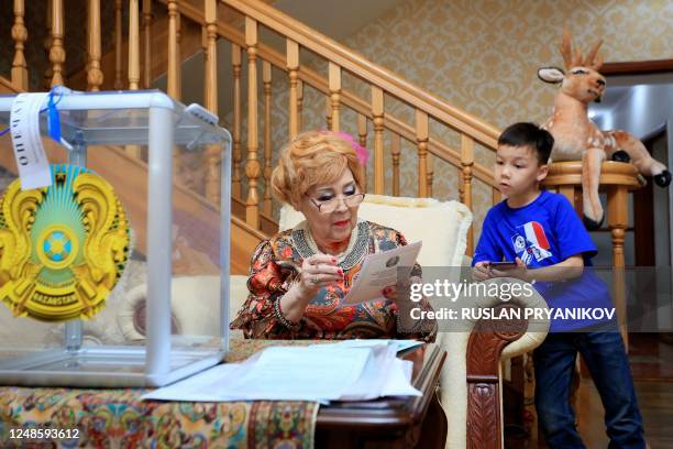 Woman votes at her home during parliamentary elections in Almaty on March 19, 2023. - Kazakhstan holds snap parliamentary elections on March 19 as...