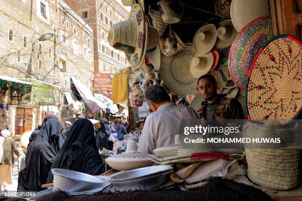 Shopkeeper displays straw hats and baskets at a market in Sanaa on March 18 ahead of the Muslim holy month of Ramadan.