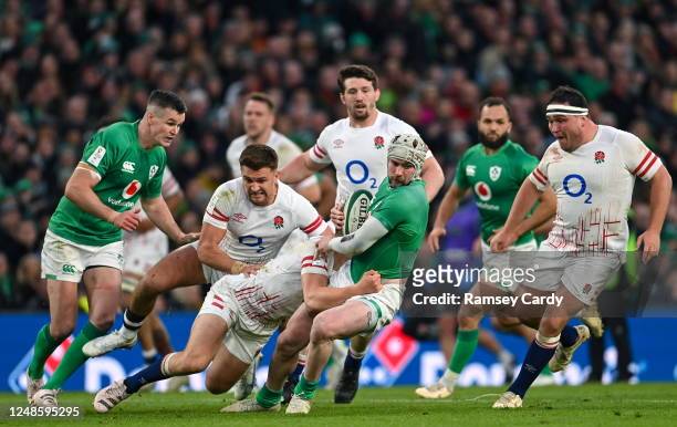 Dublin , Ireland - 18 March 2023; Mack Hansen of Ireland is tackled by Jack van Poortvliet of England during the Guinness Six Nations Rugby...