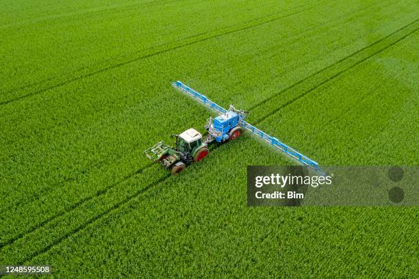tractor spraying wheat field, aerial view - nitrogen stock pictures, royalty-free photos & images
