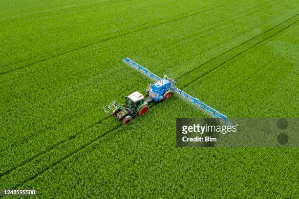 tractor spraying wheat field, aerial view - adubo equipamento agrícola imagens e fotografias de stock