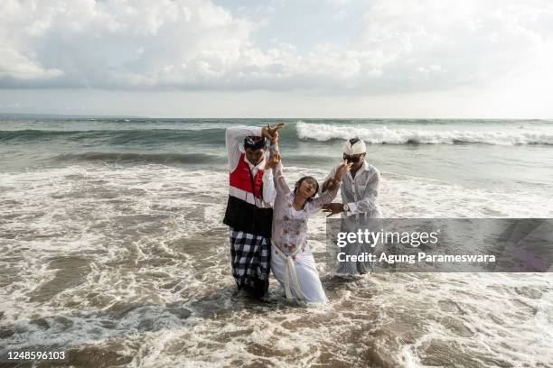 Balinese Hindus woman in a state of trance, dances during Melasti Ritual prior to Nyepi Day on March 19, 2023 at Batubolong Beach, in Canggu Bali,...